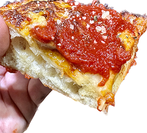 Detroit Pizza Slice with a rich tomato sauce and thick fluffy airy crust.